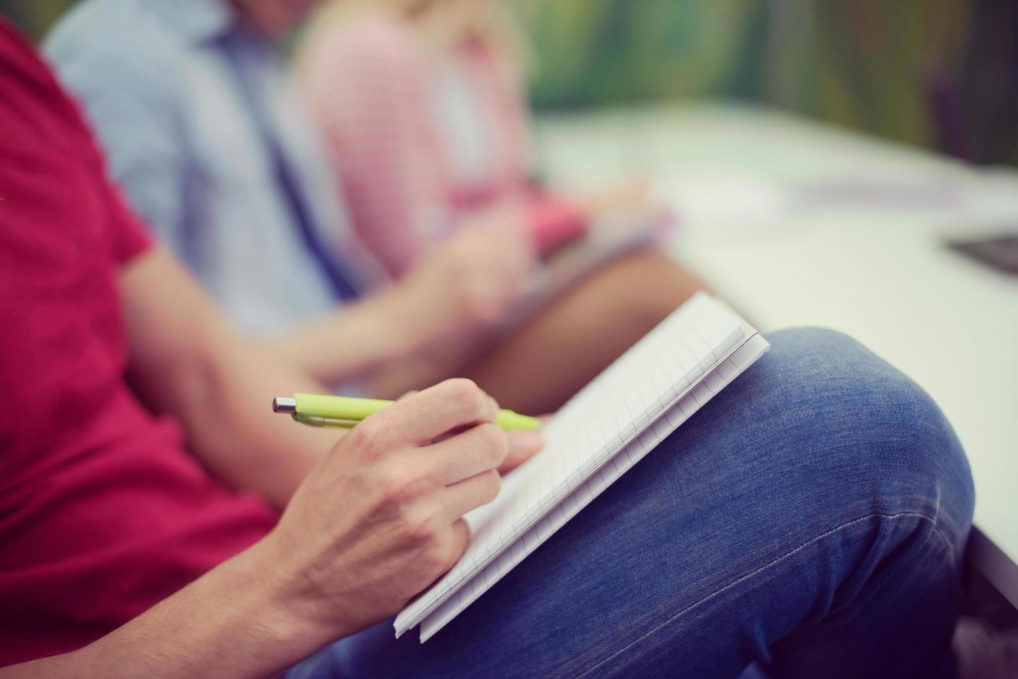 male student taking notes in classroom photo