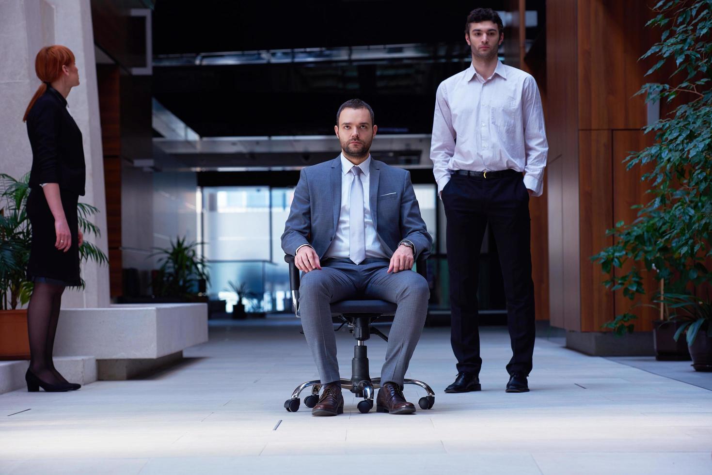 business man sitting in office chair, people group  passing by photo