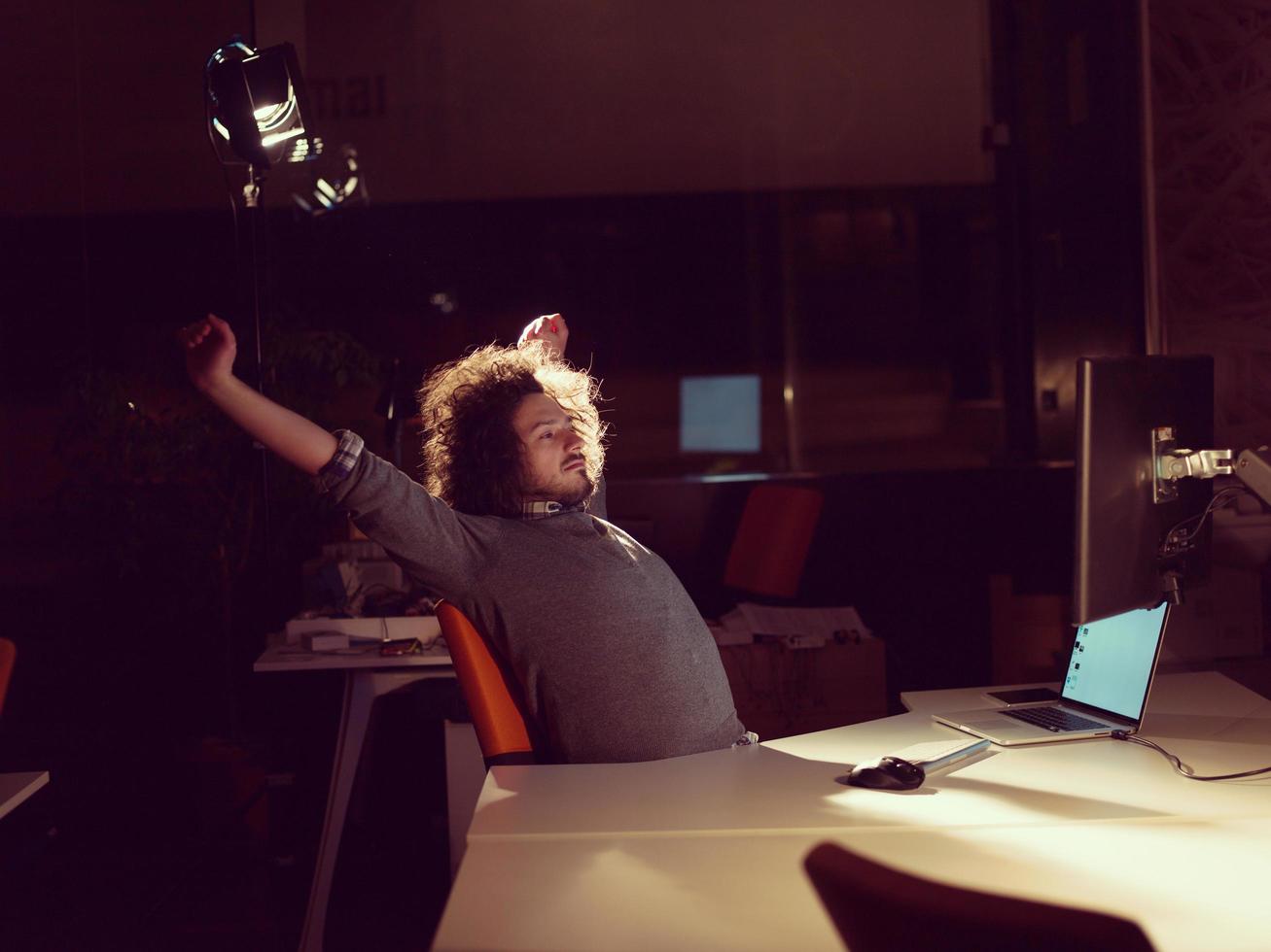 hombre trabajando en una computadora en una oficina oscura foto