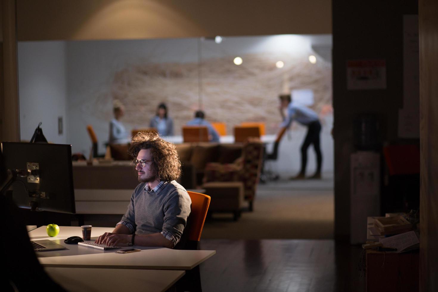 man working on computer in dark office photo