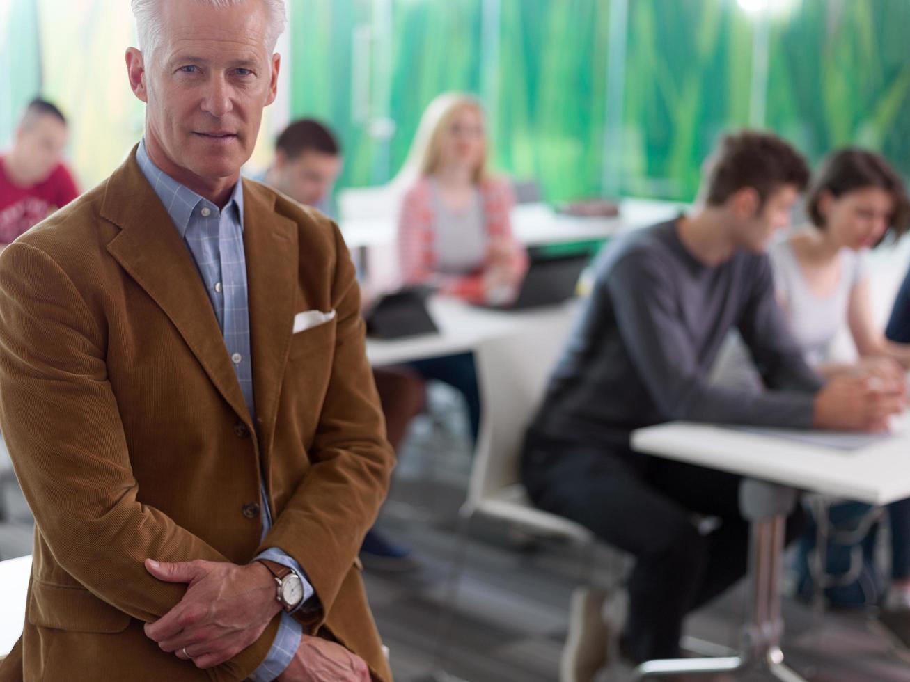 portrait of in teacher in classroom with students group in background photo