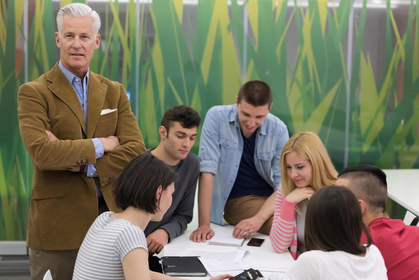 portrait of  teacher with students group in background photo