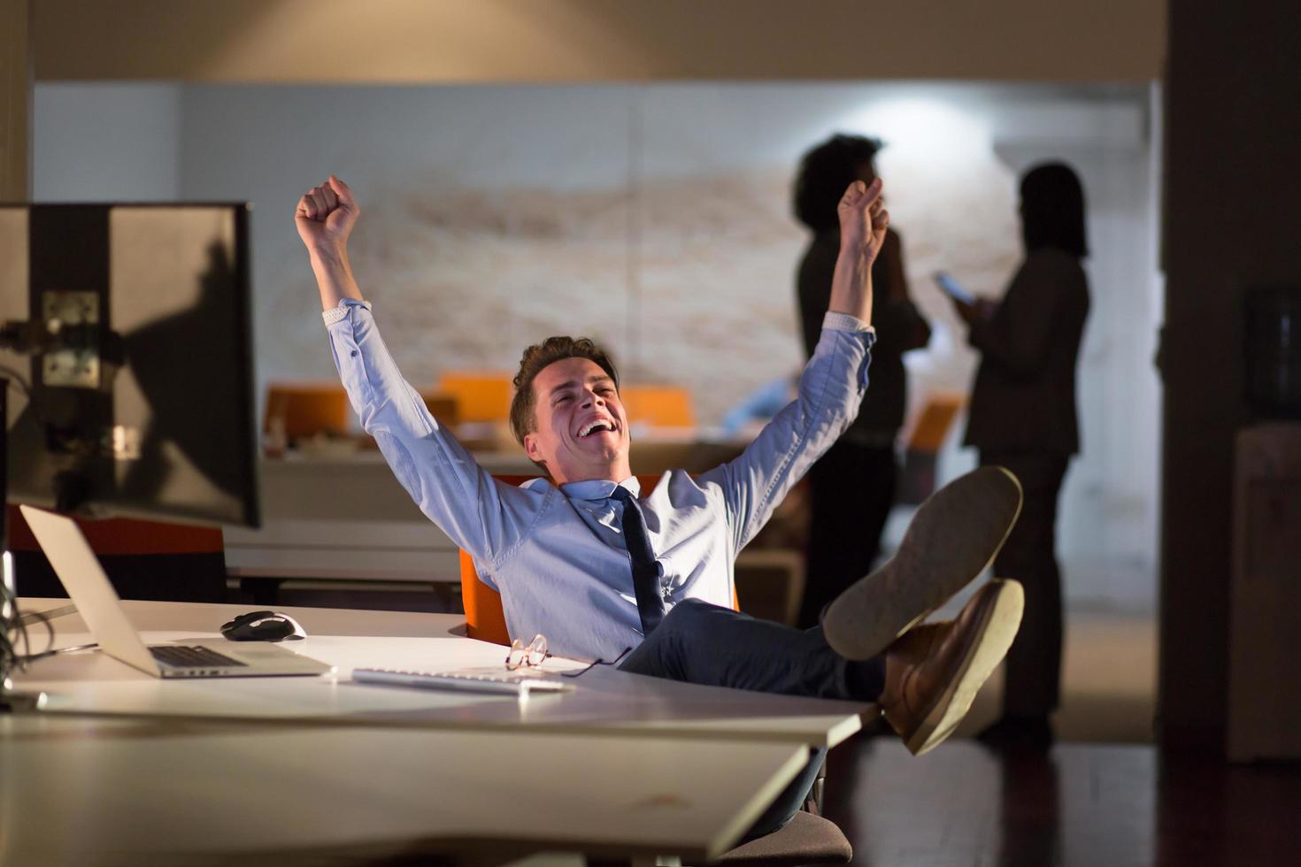 businessman sitting with legs on desk at office photo
