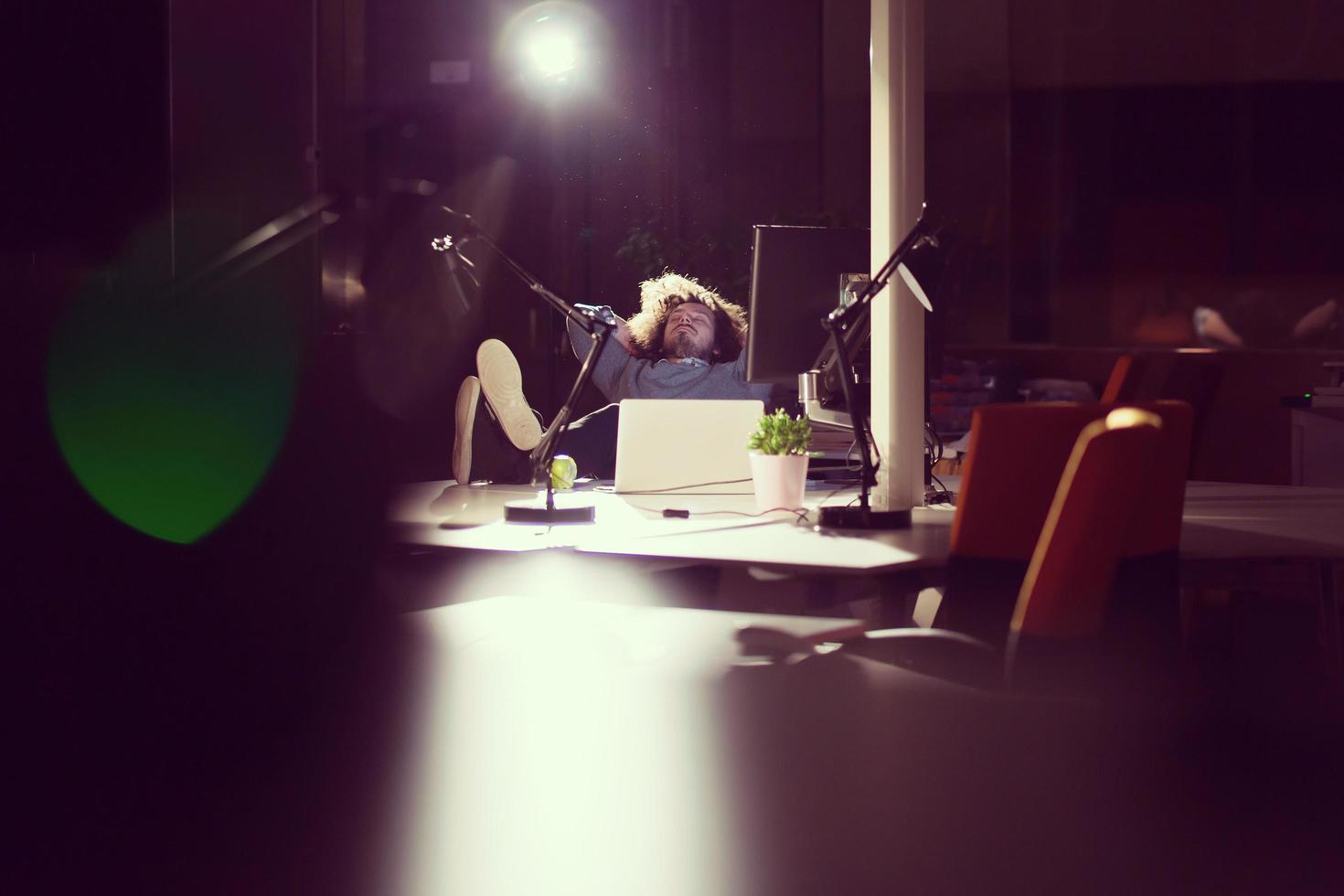 businessman sitting with legs on desk at office photo