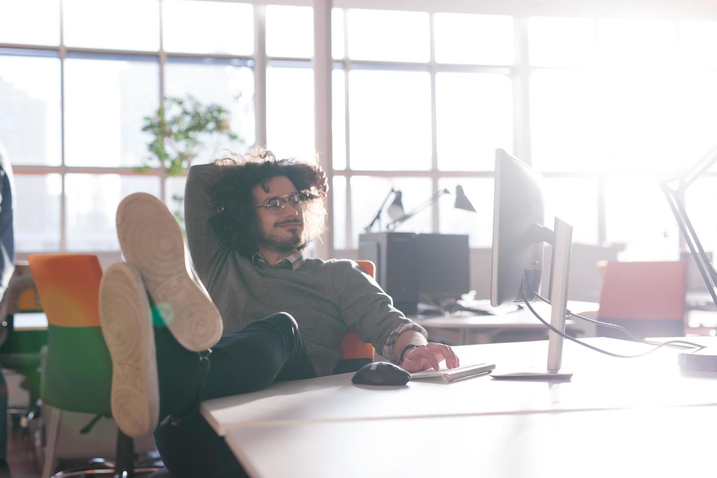 businessman sitting with legs on desk photo
