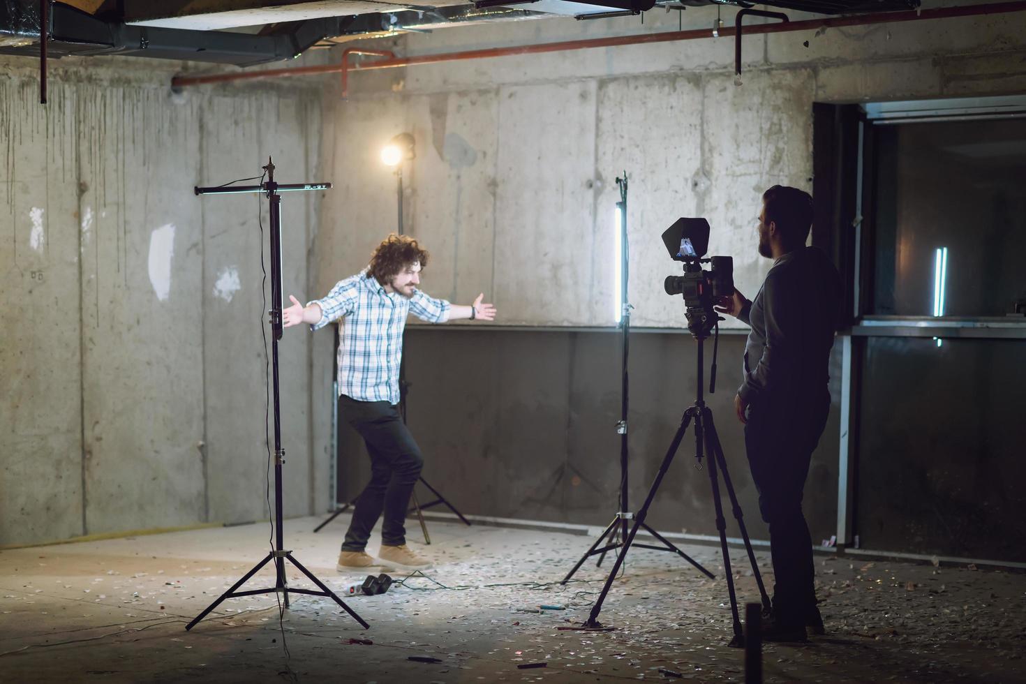 videographer recording casual businessman in front of a concrete wall photo