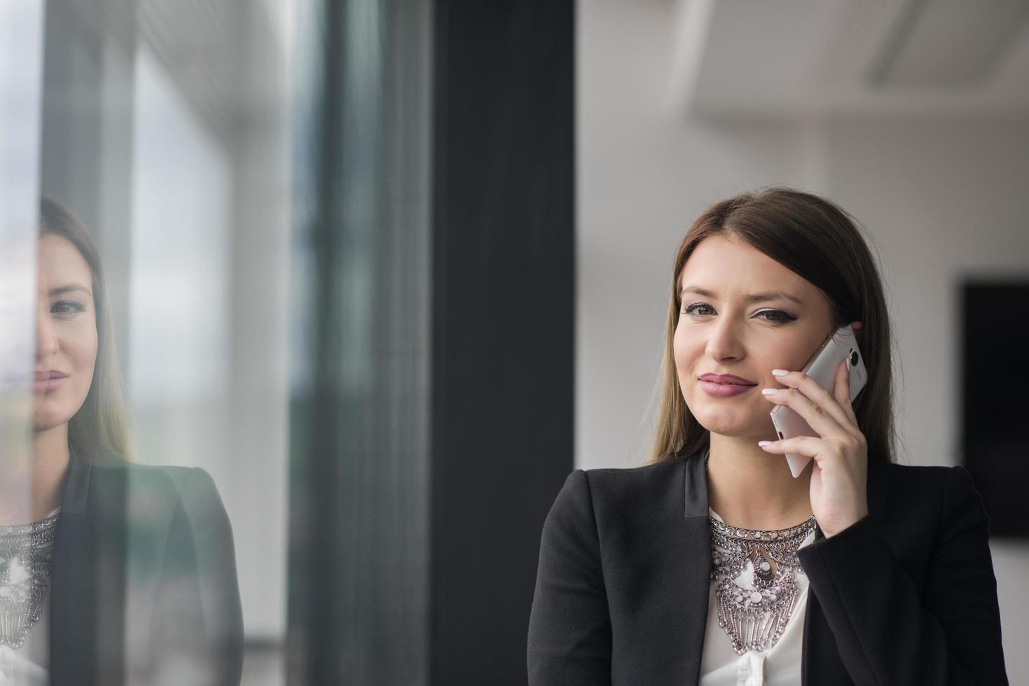Business Girl Standing In A Modern Building Near The Window With Phone photo