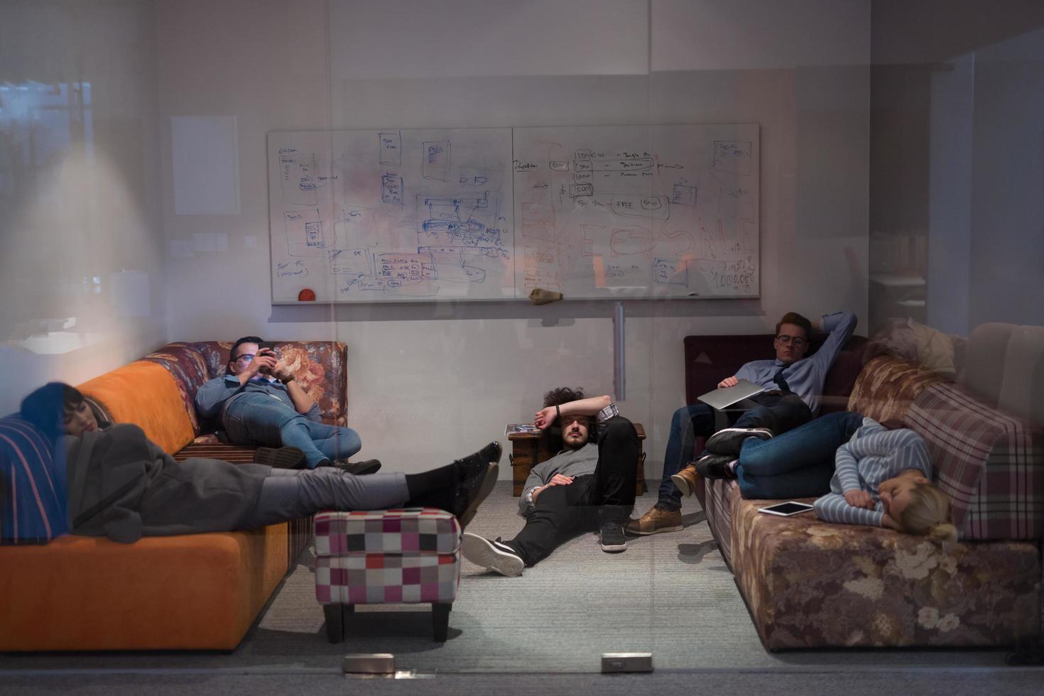 software developers sleeping on sofa in creative startup office photo