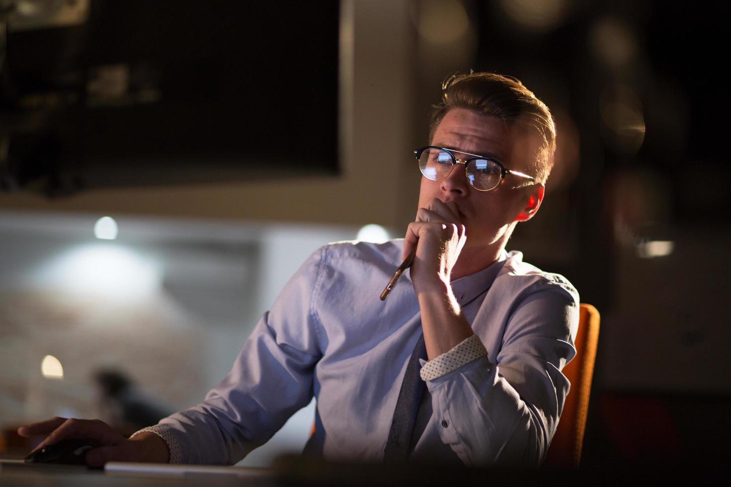 man working on computer in dark office photo