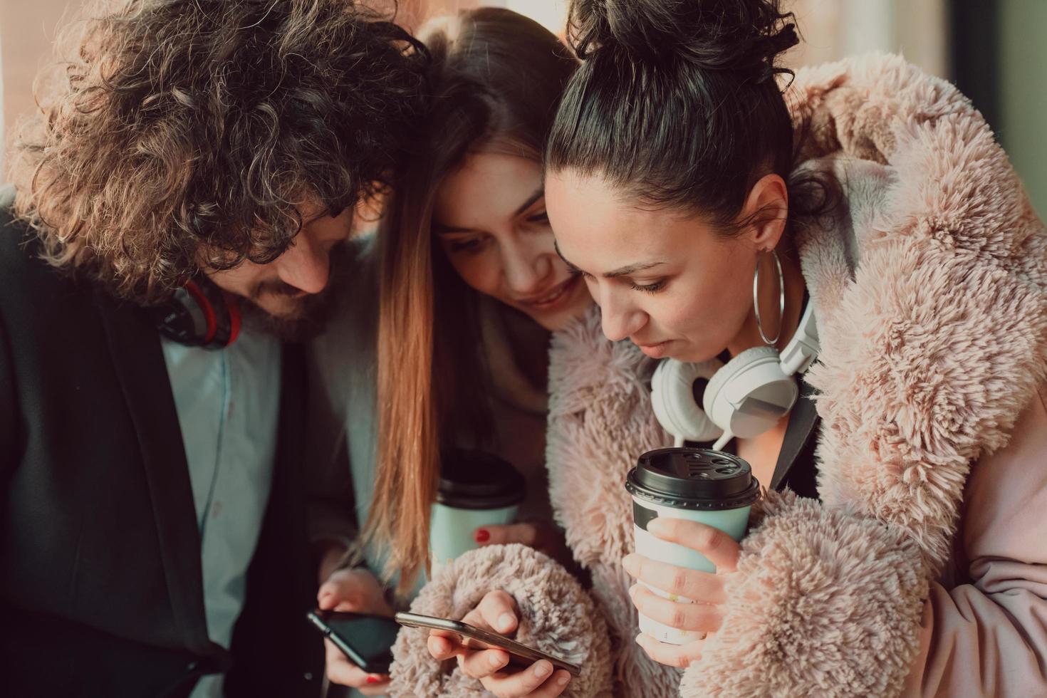 group friends stand in front of the university and use a smartphone photo