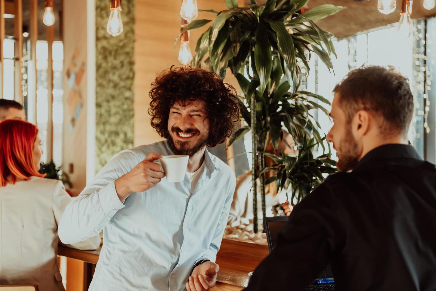 dos amigos están tomando café y hablando en un café durante un descanso de los compromisos comerciales. foto