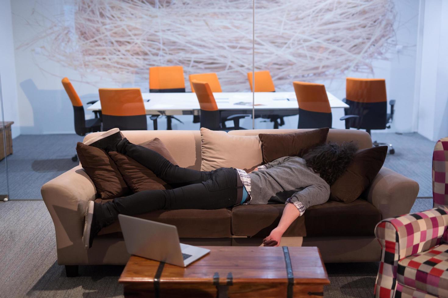 man sleeping on a sofa  in a creative office photo