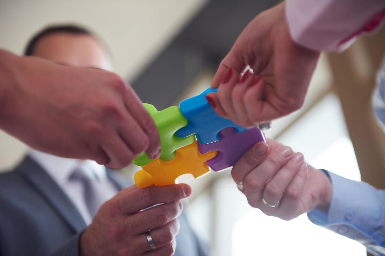 business people group assembling jigsaw puzzle photo