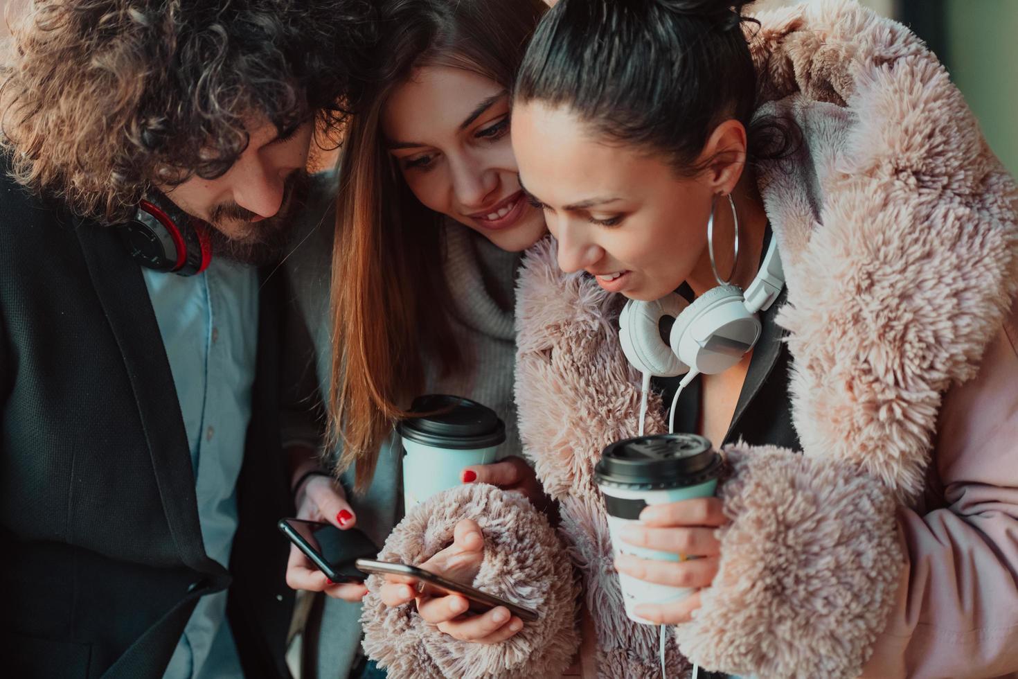 group friends stand in front of the university and use a smartphone photo
