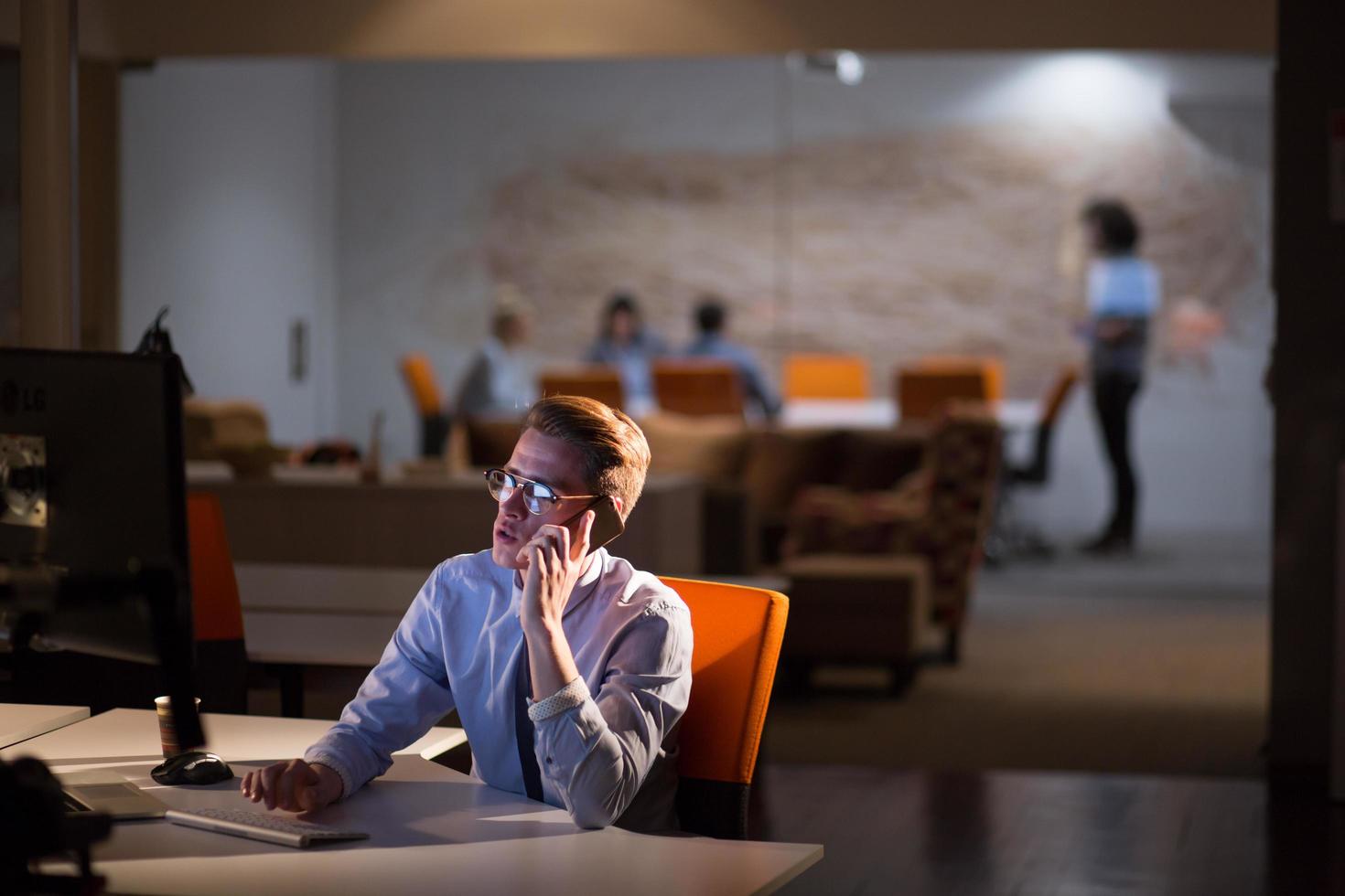 man using mobile phone in dark office photo