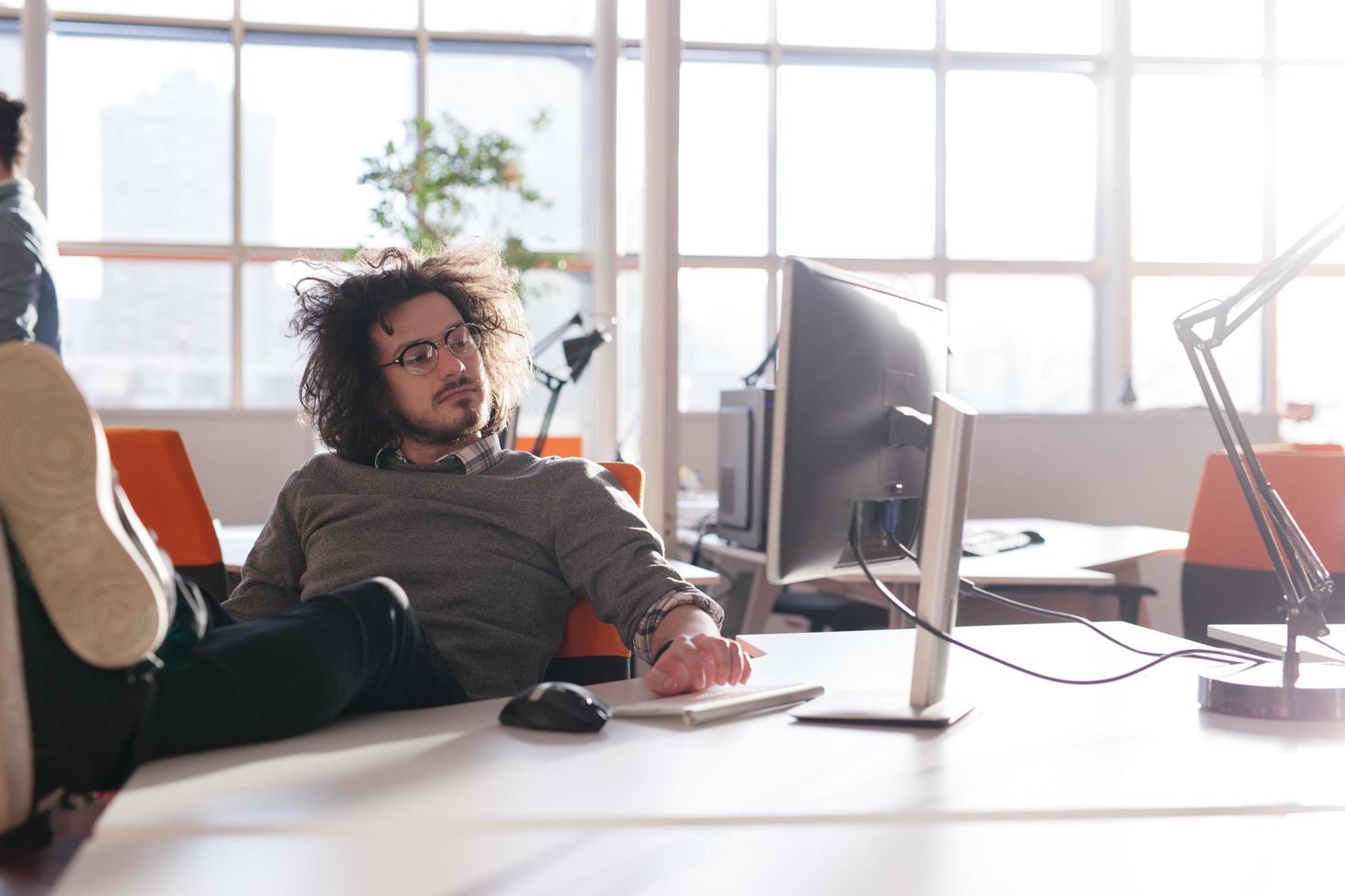 businessman sitting with legs on desk photo