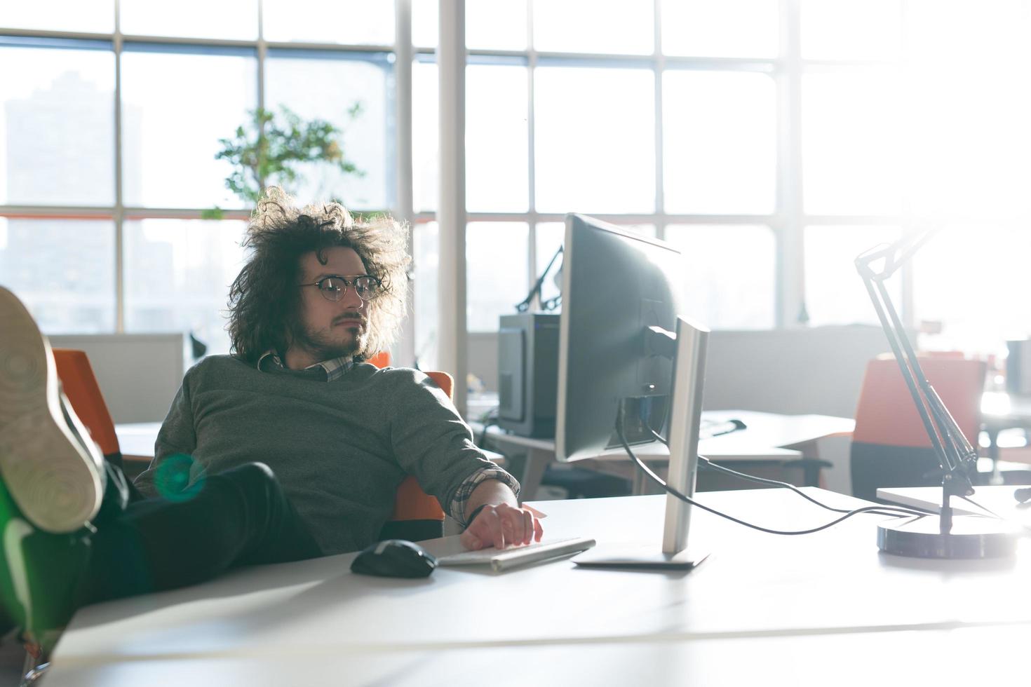 businessman sitting with legs on desk photo