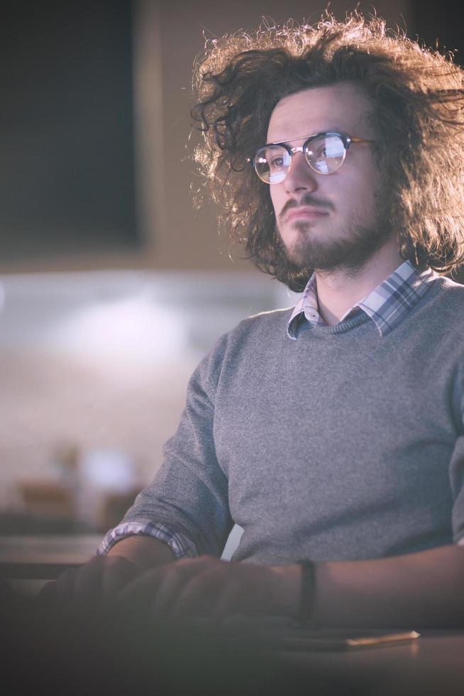 man working on computer in dark office photo