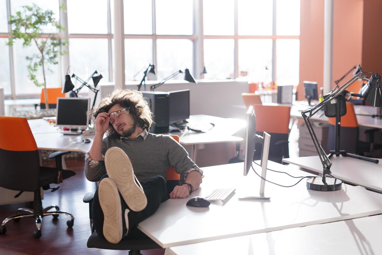 businessman sitting with legs on desk photo