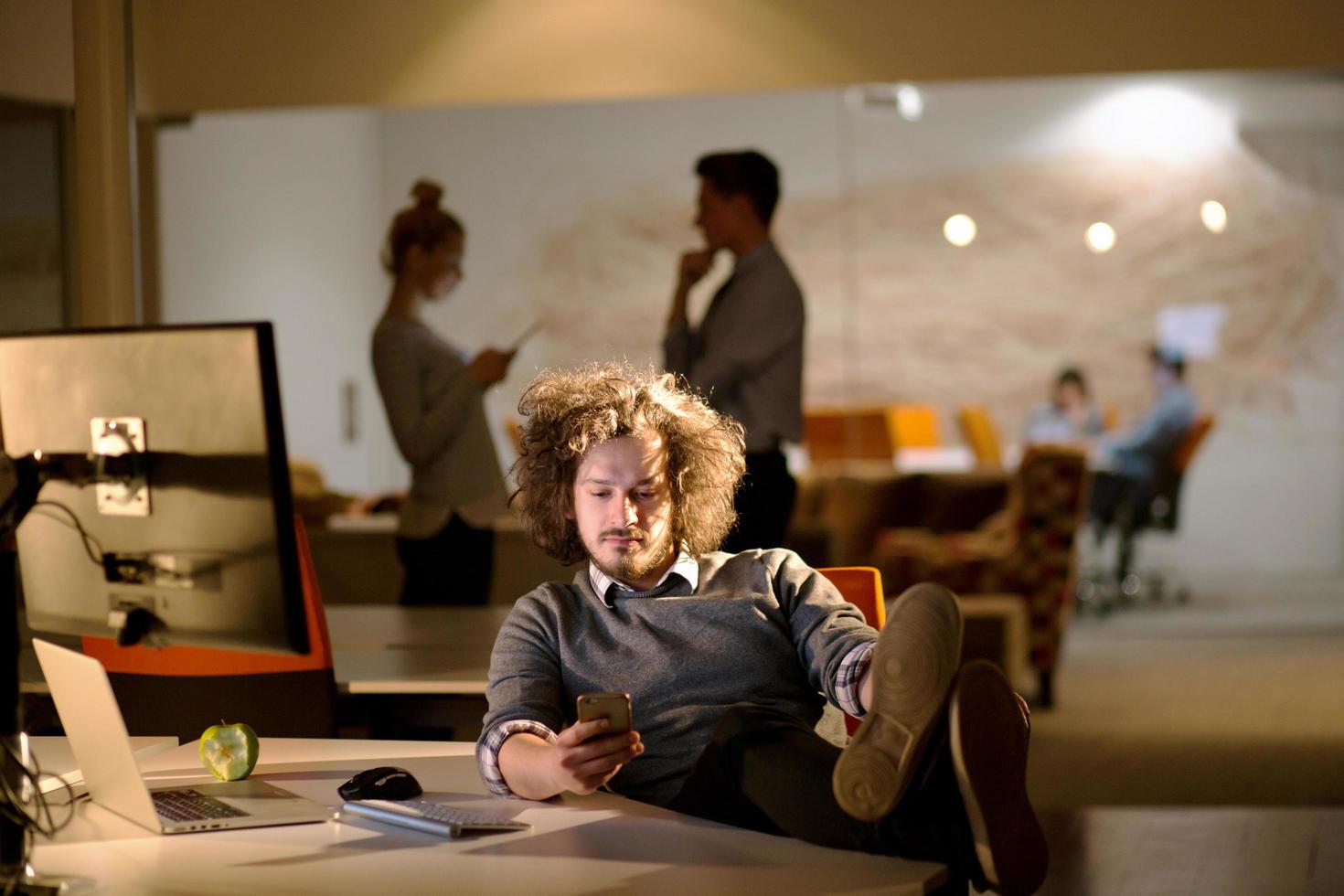 businessman sitting with legs on desk at office photo