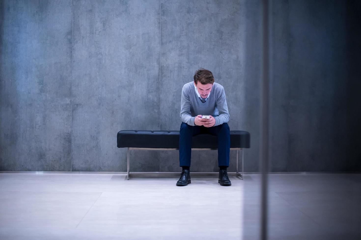 businessman using smart phone while sitting on the bench photo