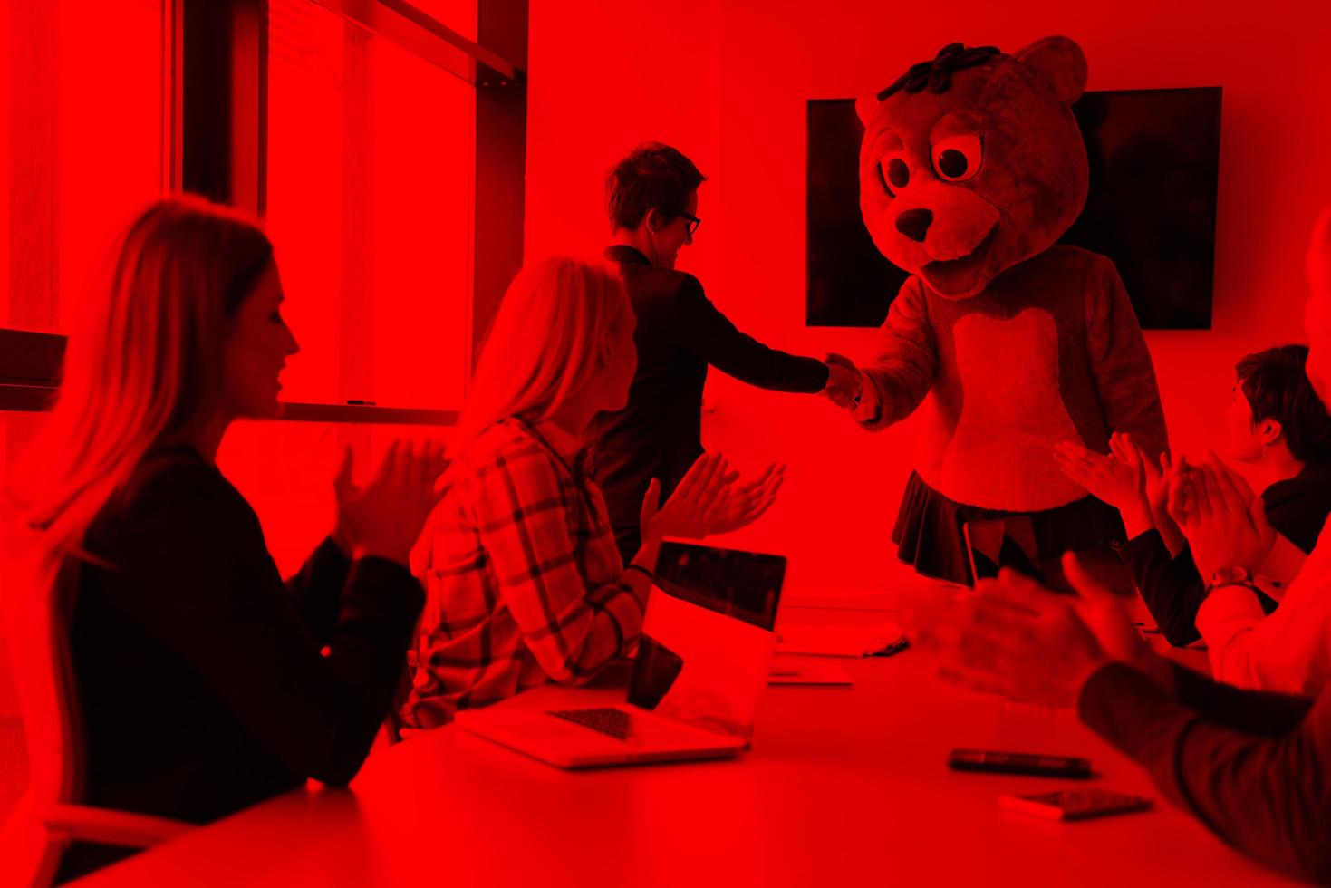 boss dresed as bear having fun with business people in trendy office photo