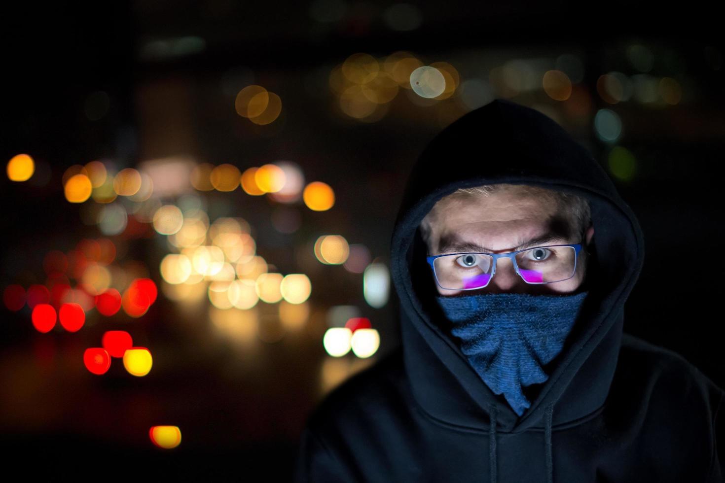 hacker using laptop computer while working in dark office photo