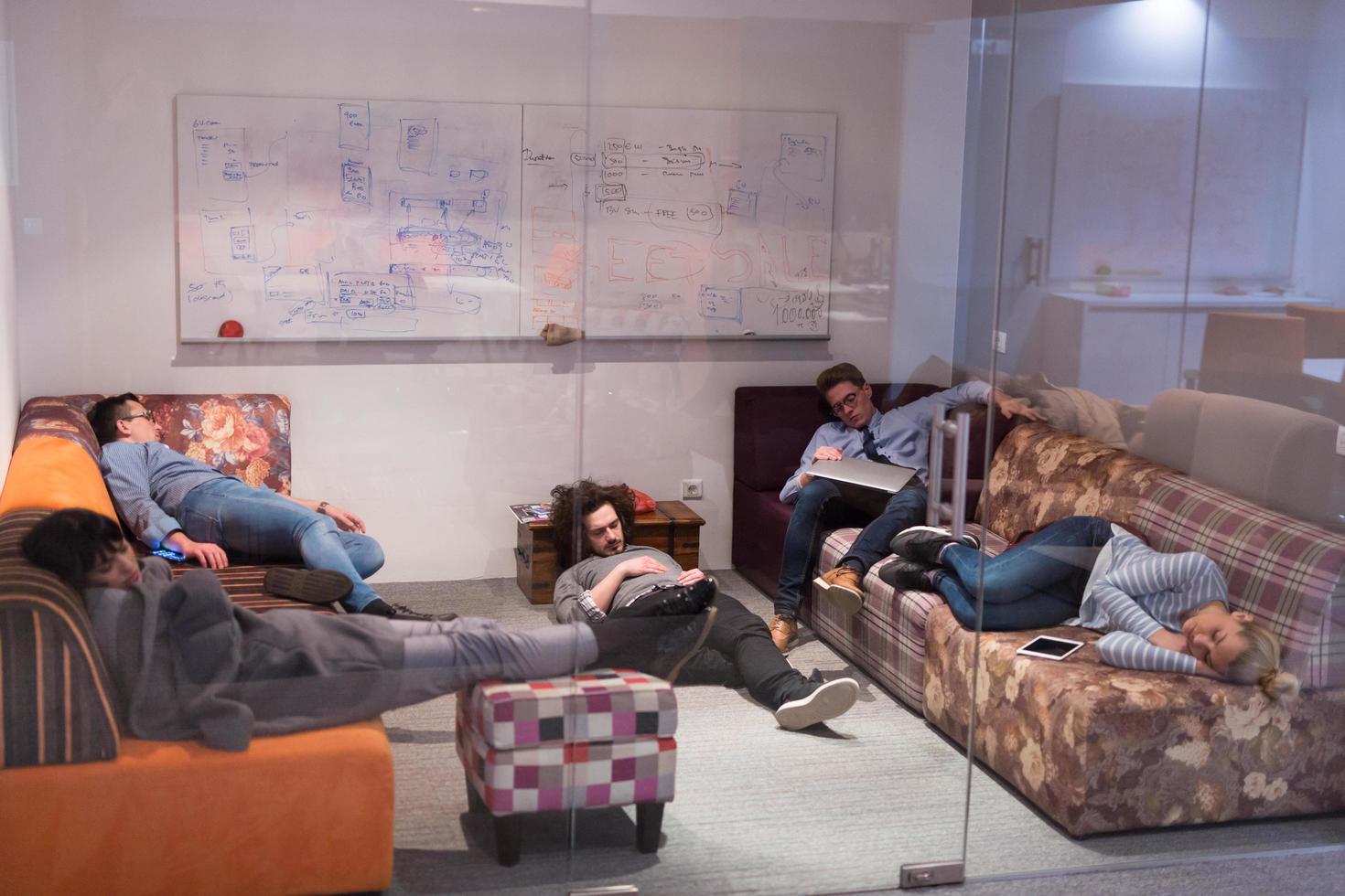 software developers sleeping on sofa in creative startup office photo