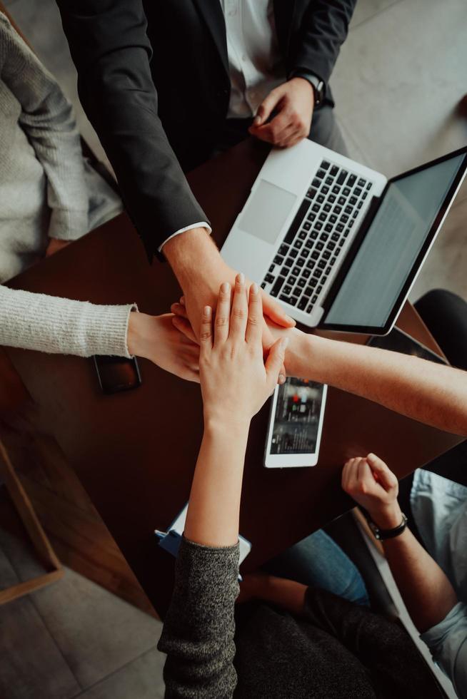 Close up of young business people putting their hands together. Stack of hands. Unity and teamwork concept.. photo