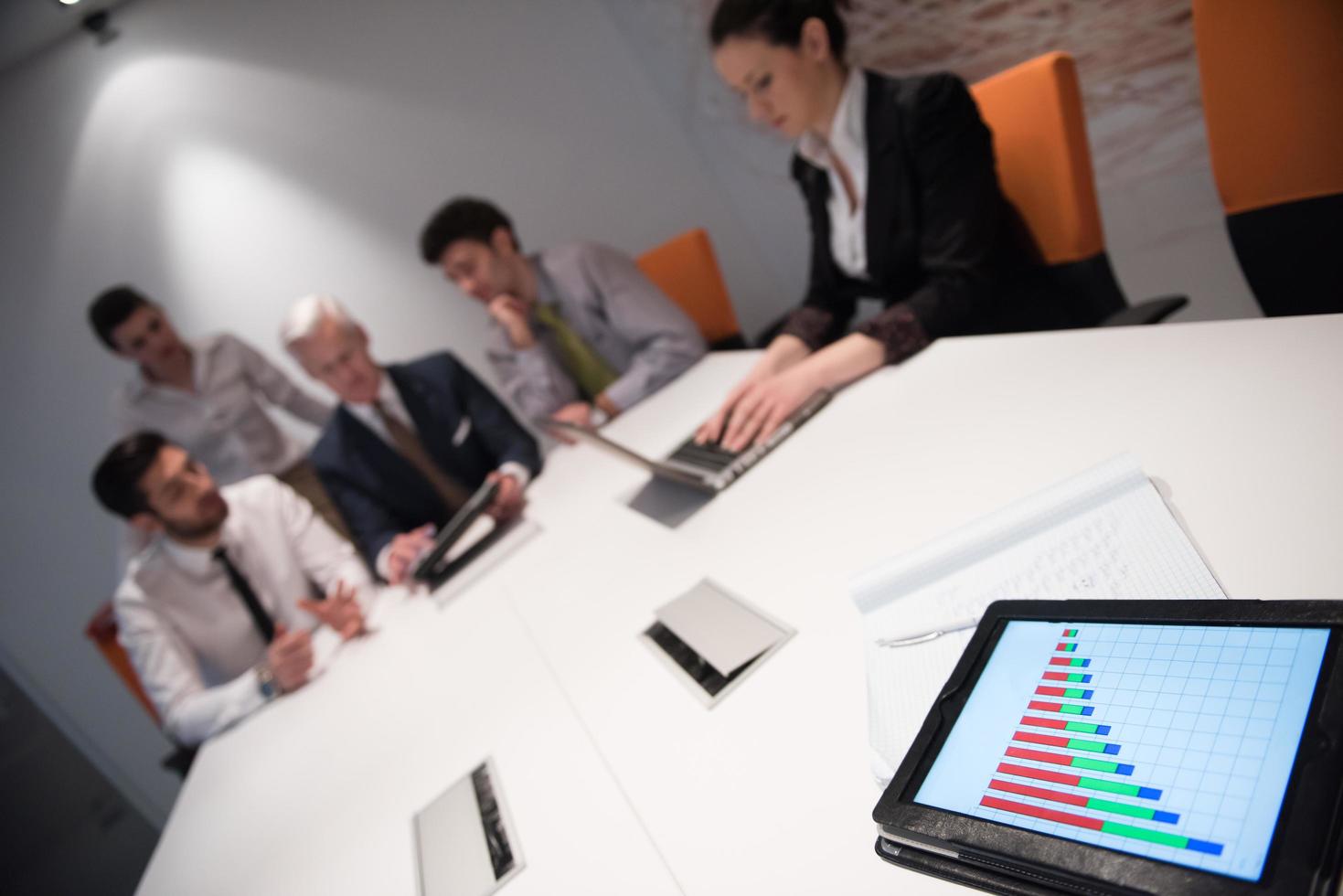 close up of touchpad with analytics documents at business meeting photo
