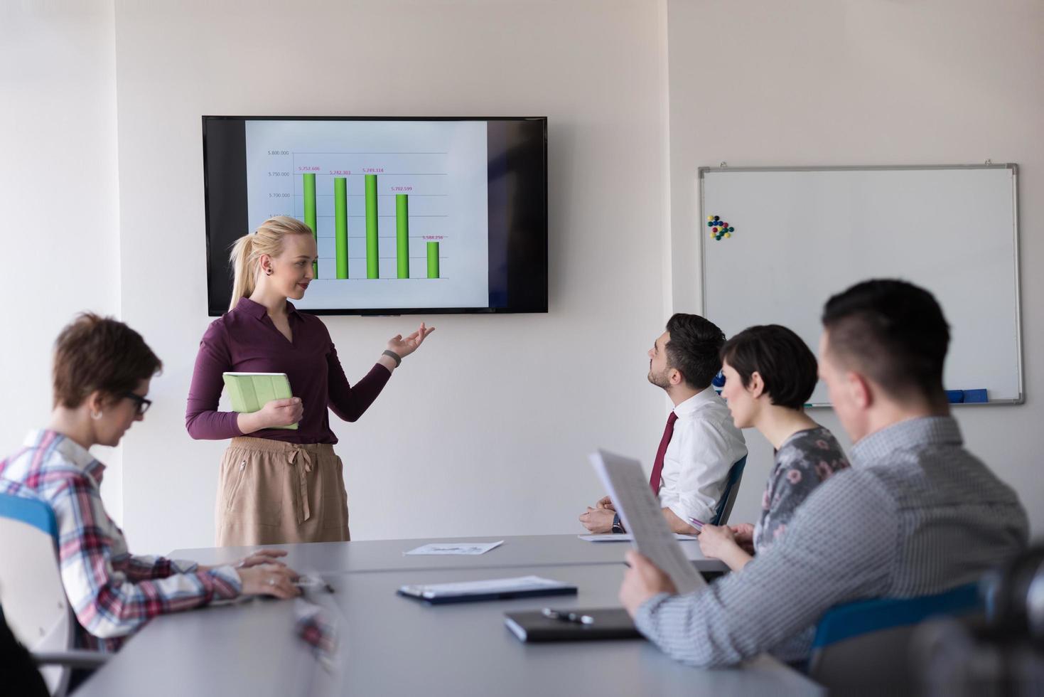 portrait of young business woman at office with team on meeting in background photo