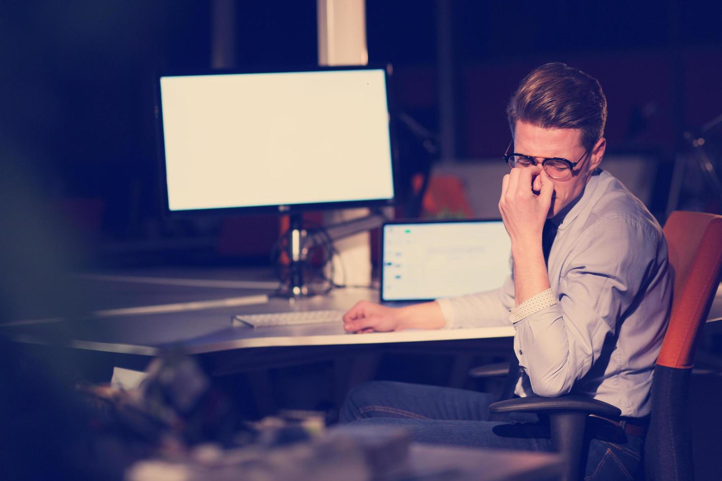 man working on computer in dark office photo