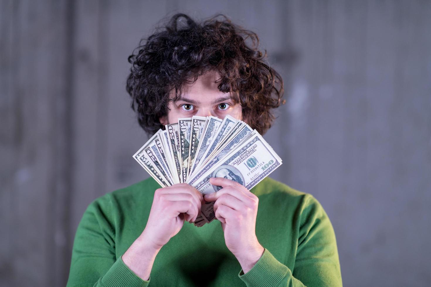 hombre de negocios que muestra una extensión de dinero en efectivo en dólares estadounidenses foto