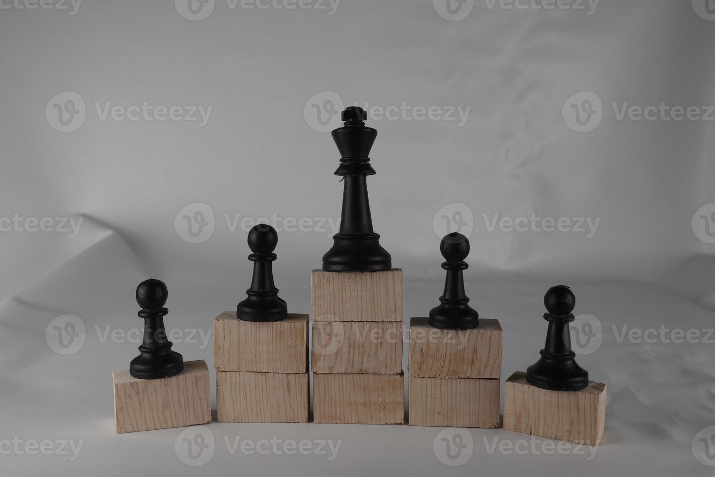 Chess pawn on the bottom and a chess queen on top, a concept to