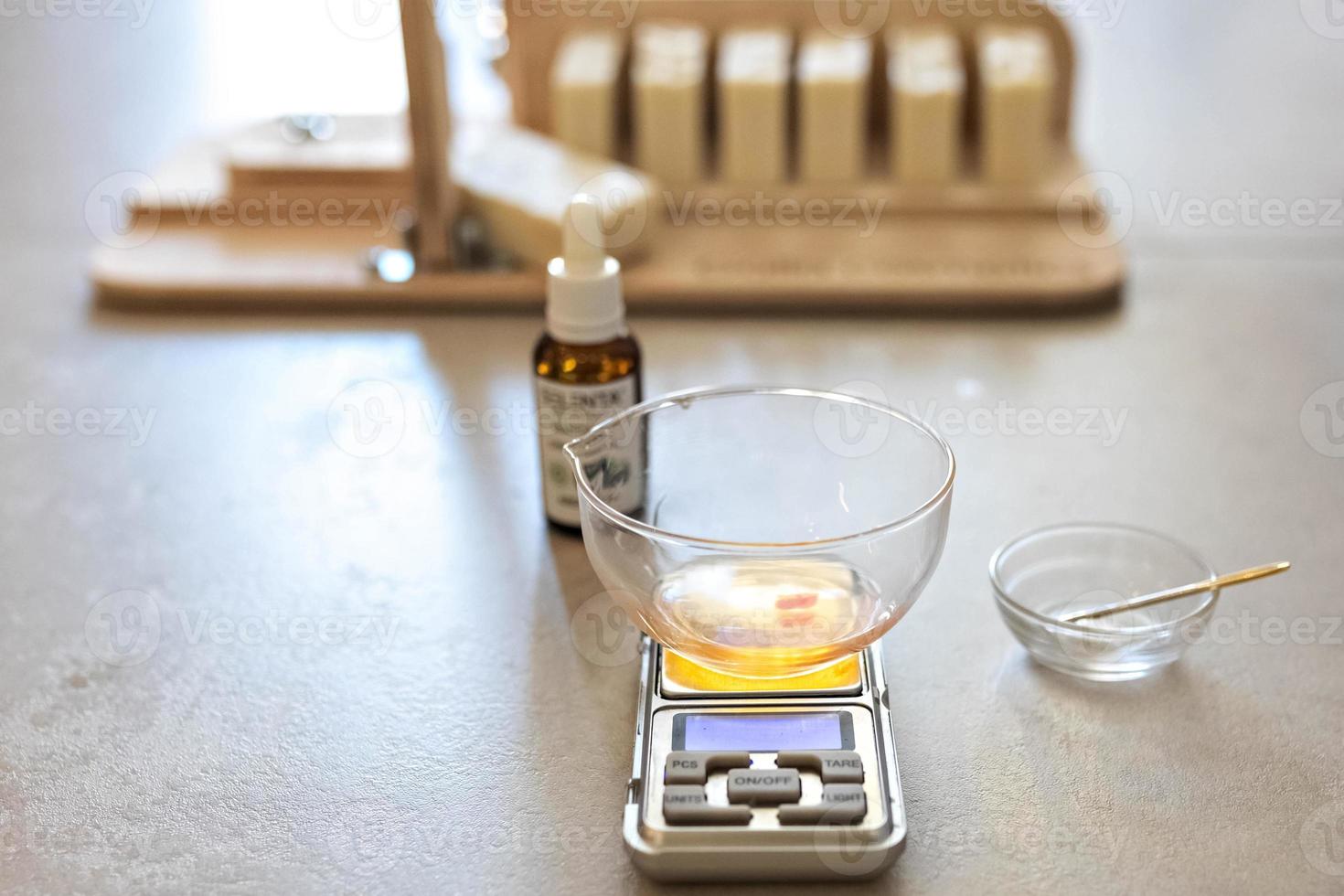 A soap-maker weighs aromatic oils for making cosmetics on a kitchen scale. Home spa. Small business photo