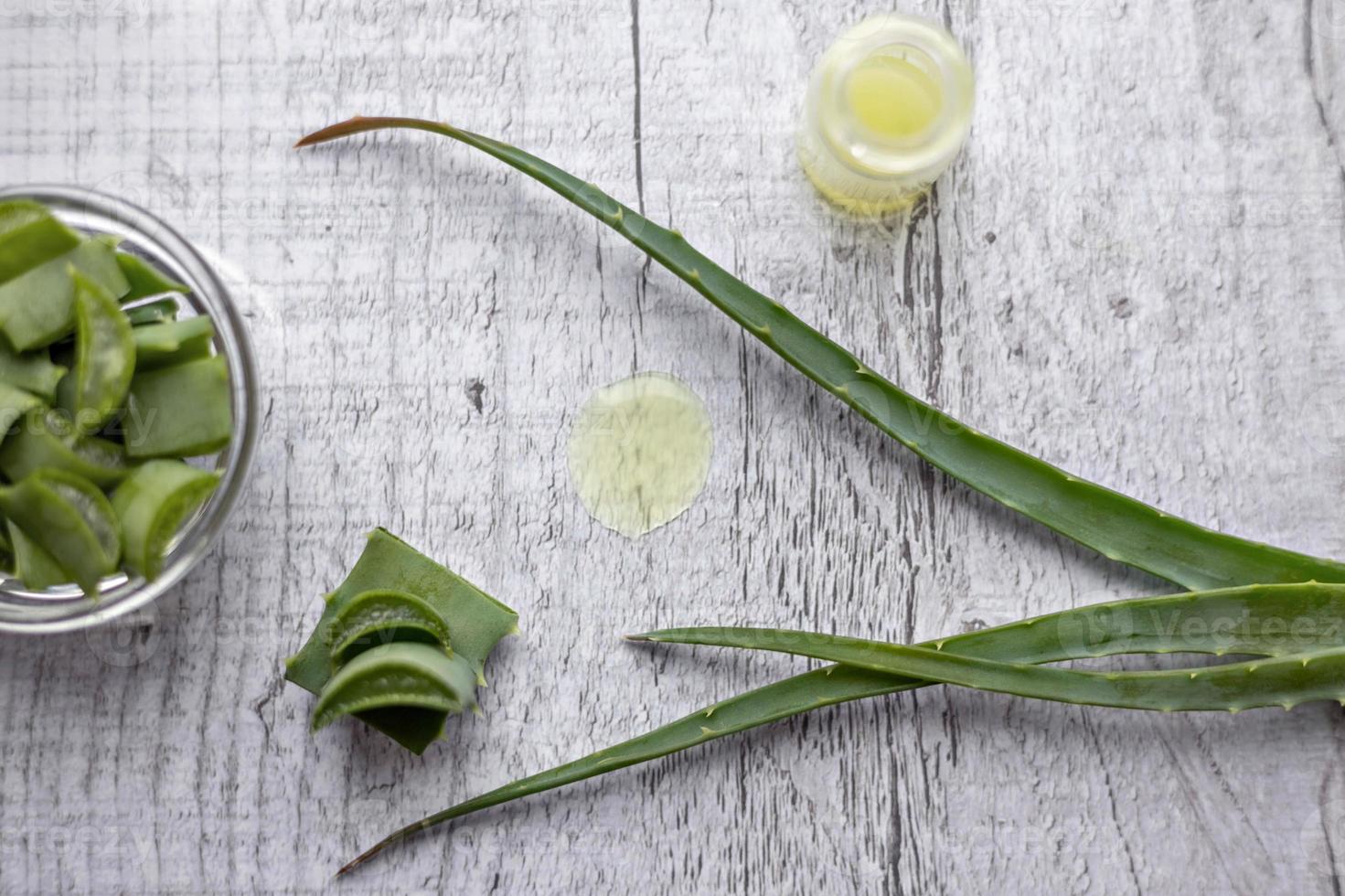 trozos de planta de aloe con gel en el interior en un tazón de vidrio de cerca. medicina alternativa. colección de jugo de aloe, para el tratamiento de enfermedades de la piel. foto