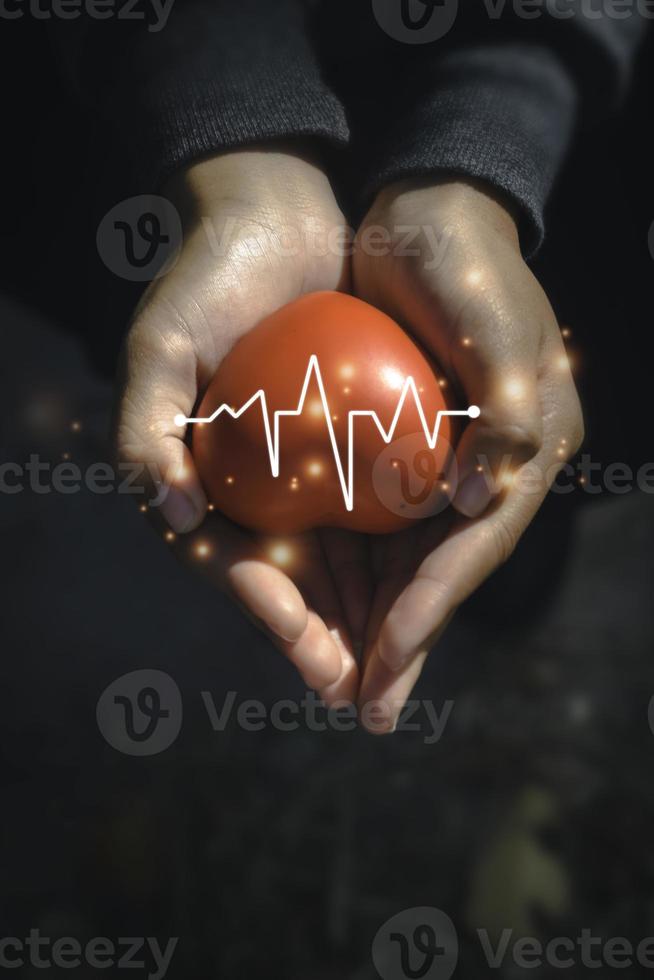 A hand holding red heart.She is Left  right hand holding it.heart health, happy volunteer charity,The photo shows the principle of caring and good health.