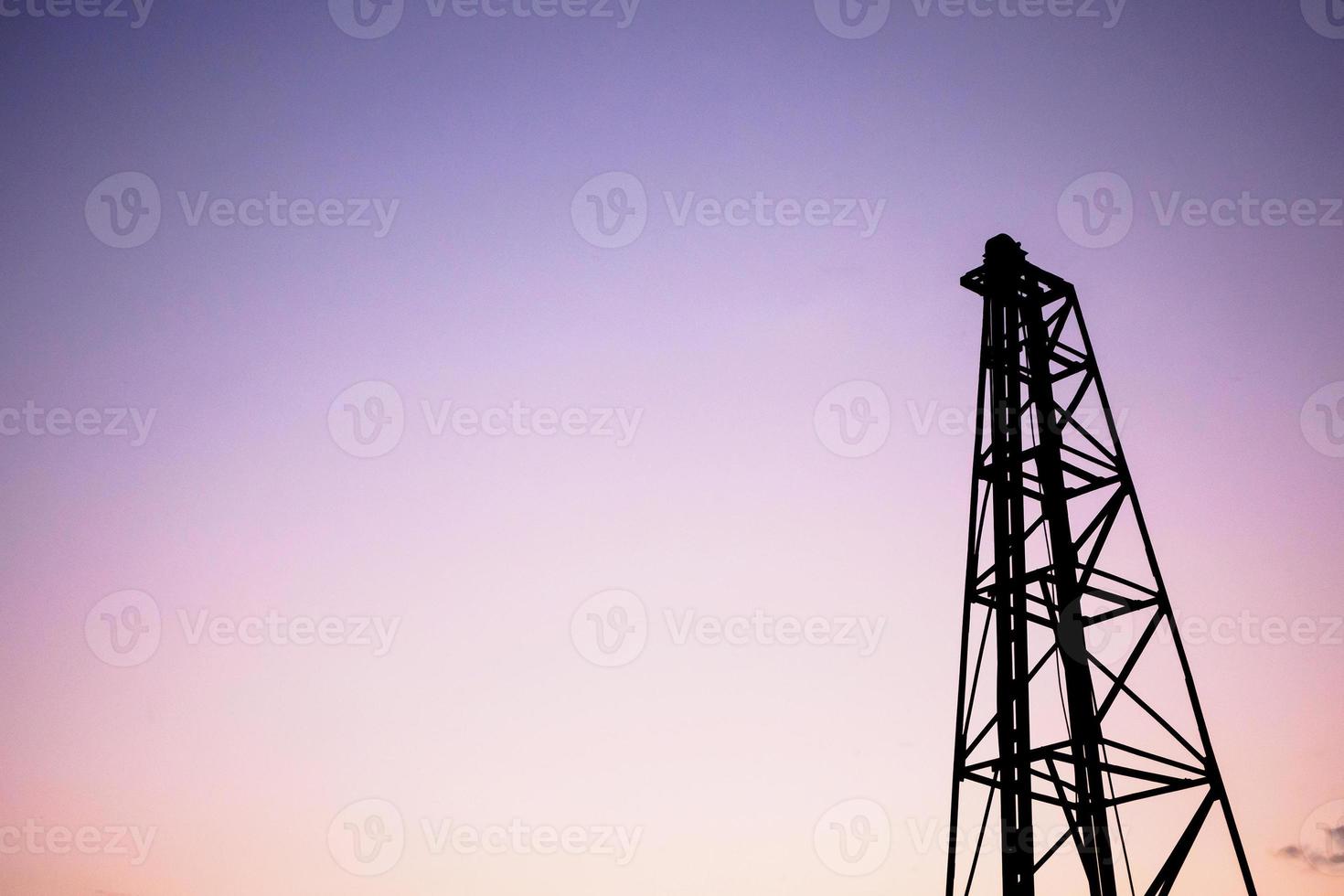 Silhouette pile driver at construction site photo