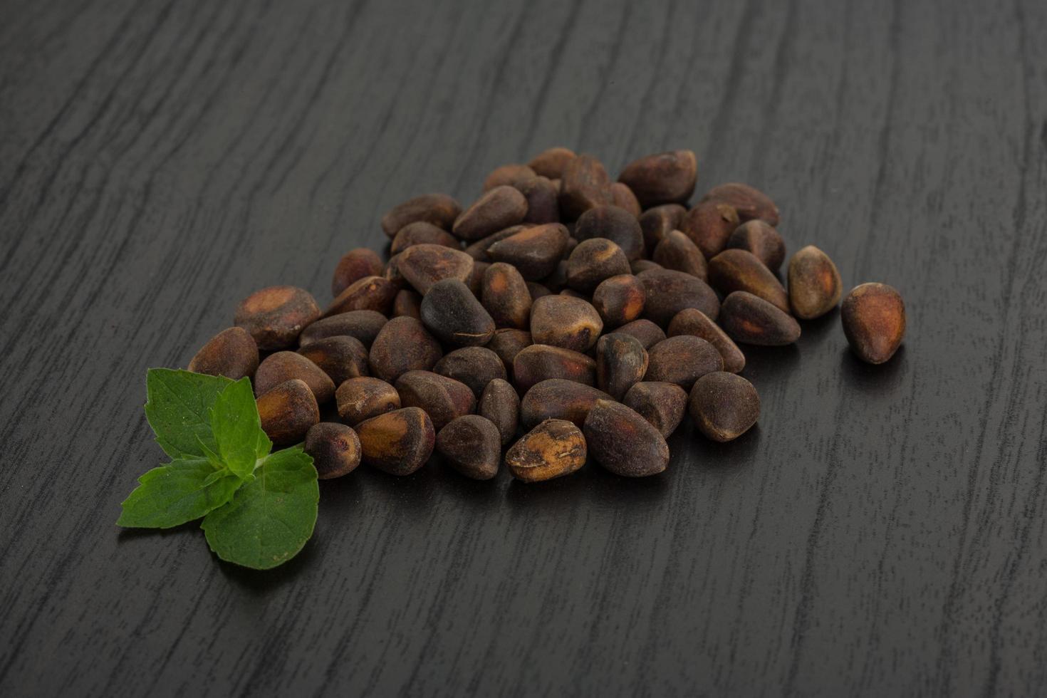 Cedar nuts on wooden background photo