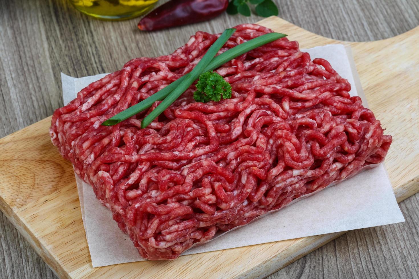 Minced beef on wooden board and wooden background photo