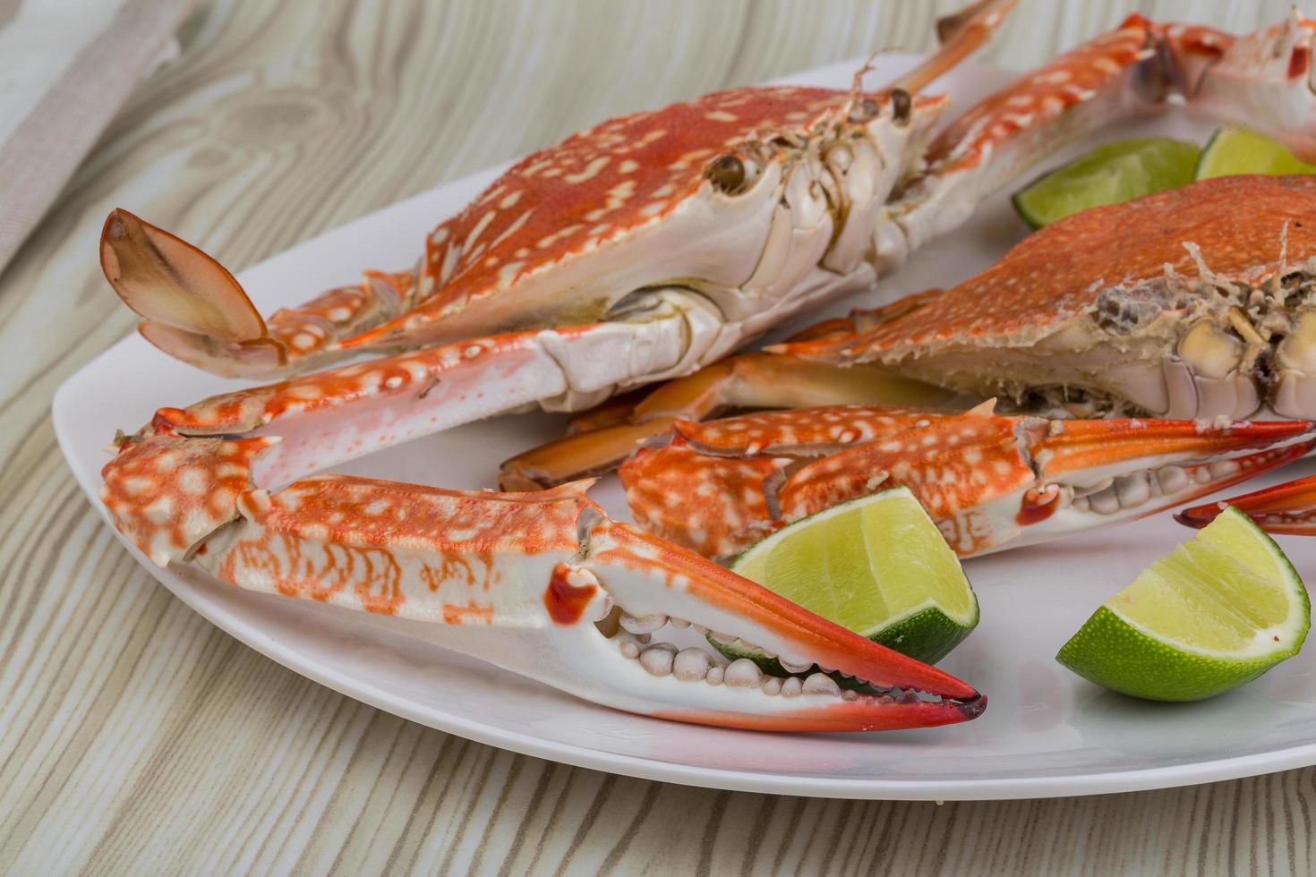 Boiled crabs on the plate and wooden background photo