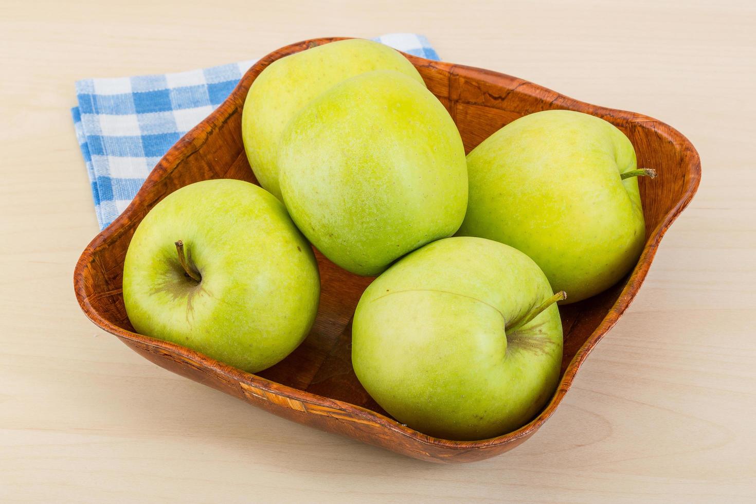 manzana verde en un recipiente sobre fondo de madera foto