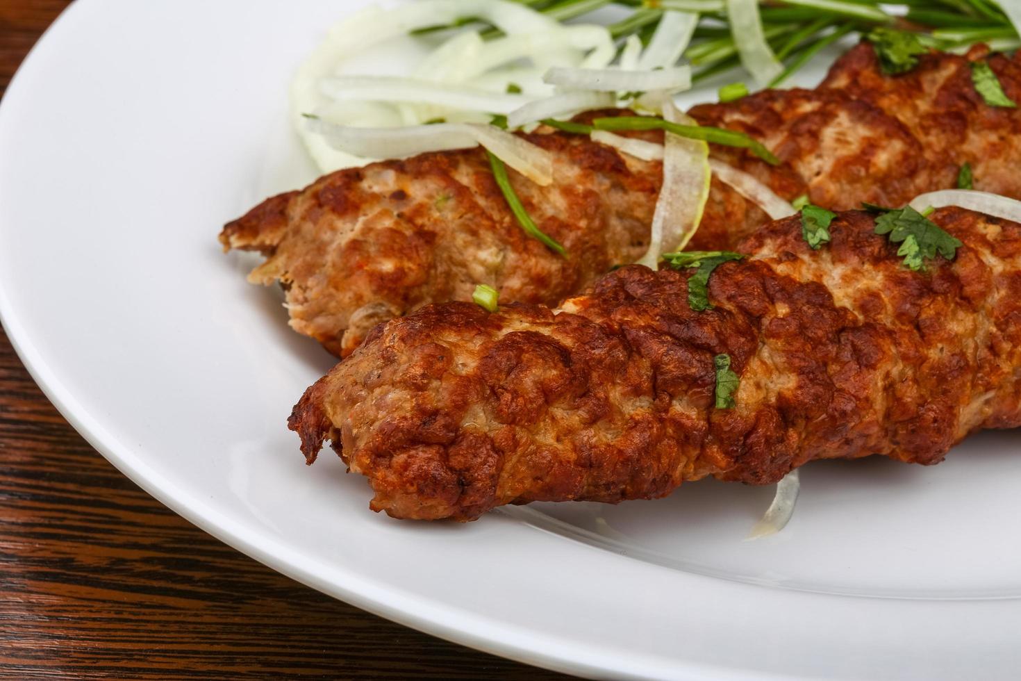 Beef kebab on the plate and wooden background photo