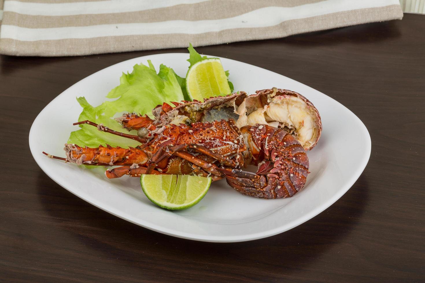 Spiny lobster on the plate and wooden background photo