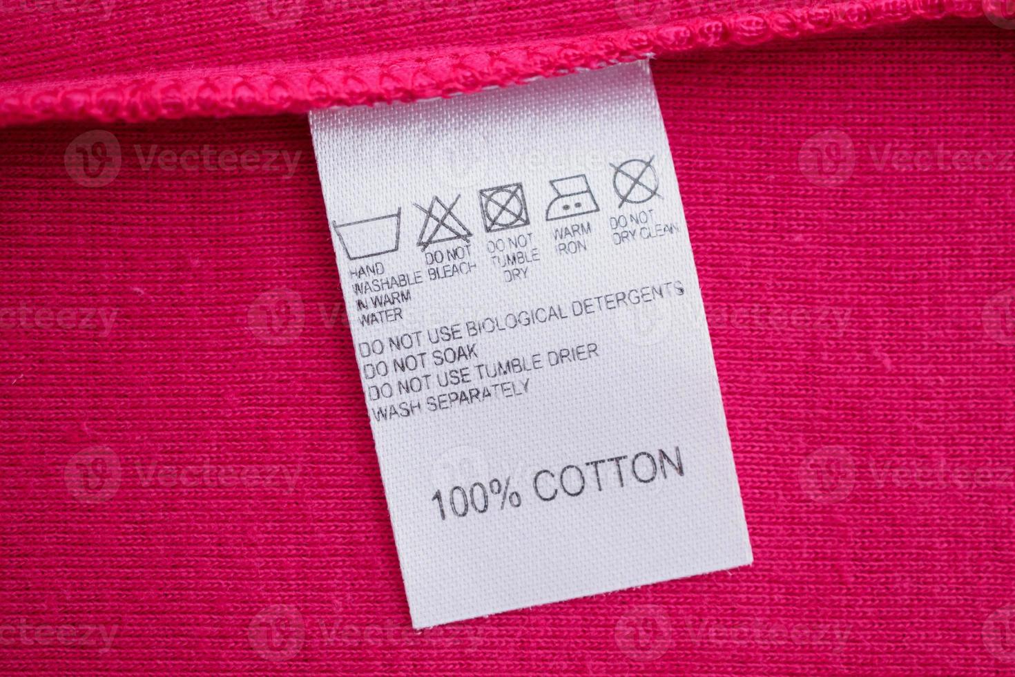 White laundry care washing instructions clothes label on red cotton shirt photo