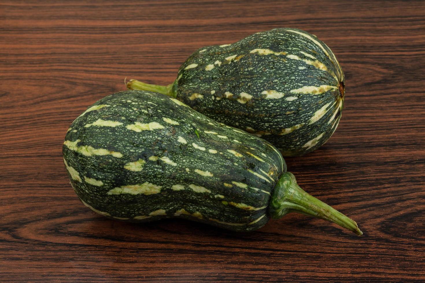 Green pumpkin on wooden background photo