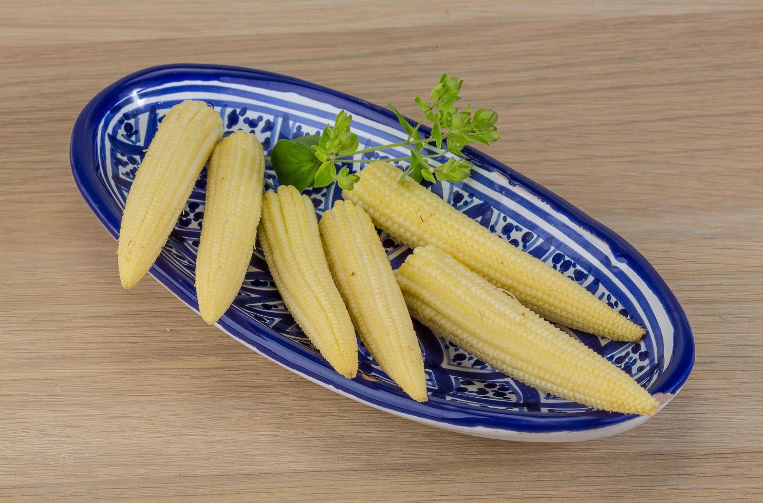 Baby corn in a bowl on wooden background photo