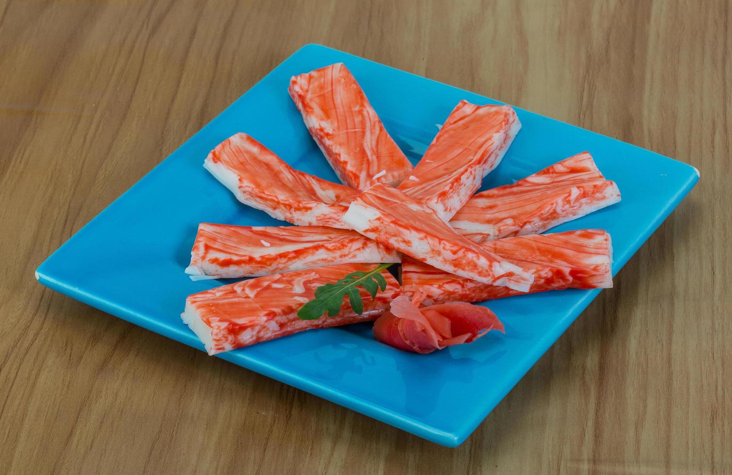 Crab sticks on the plate and wooden background photo