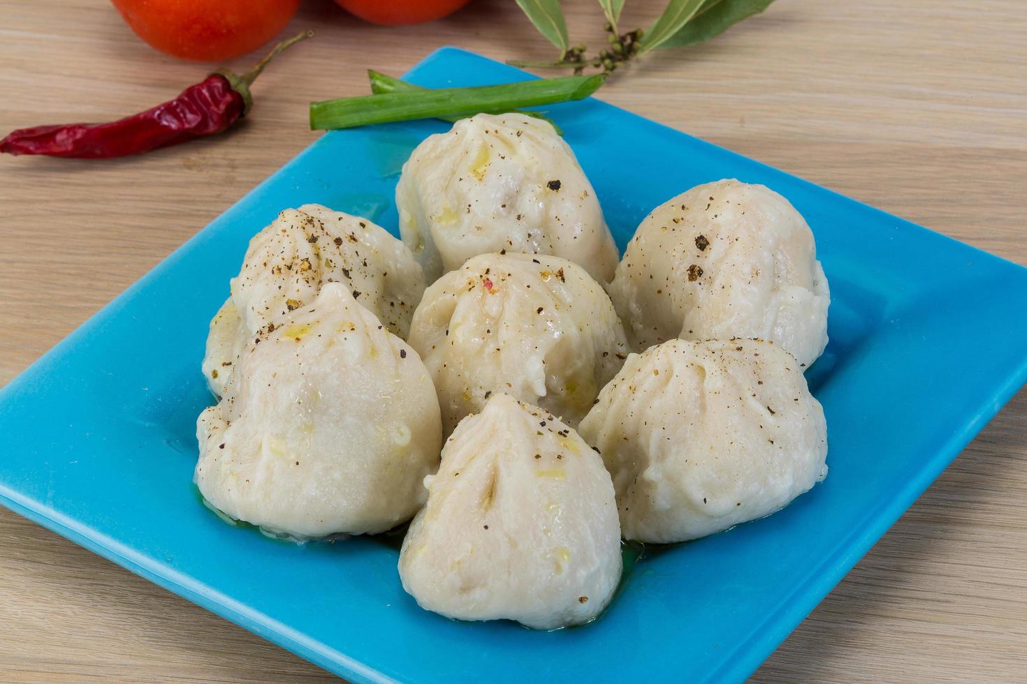 Khinkali on the plate and wooden background photo