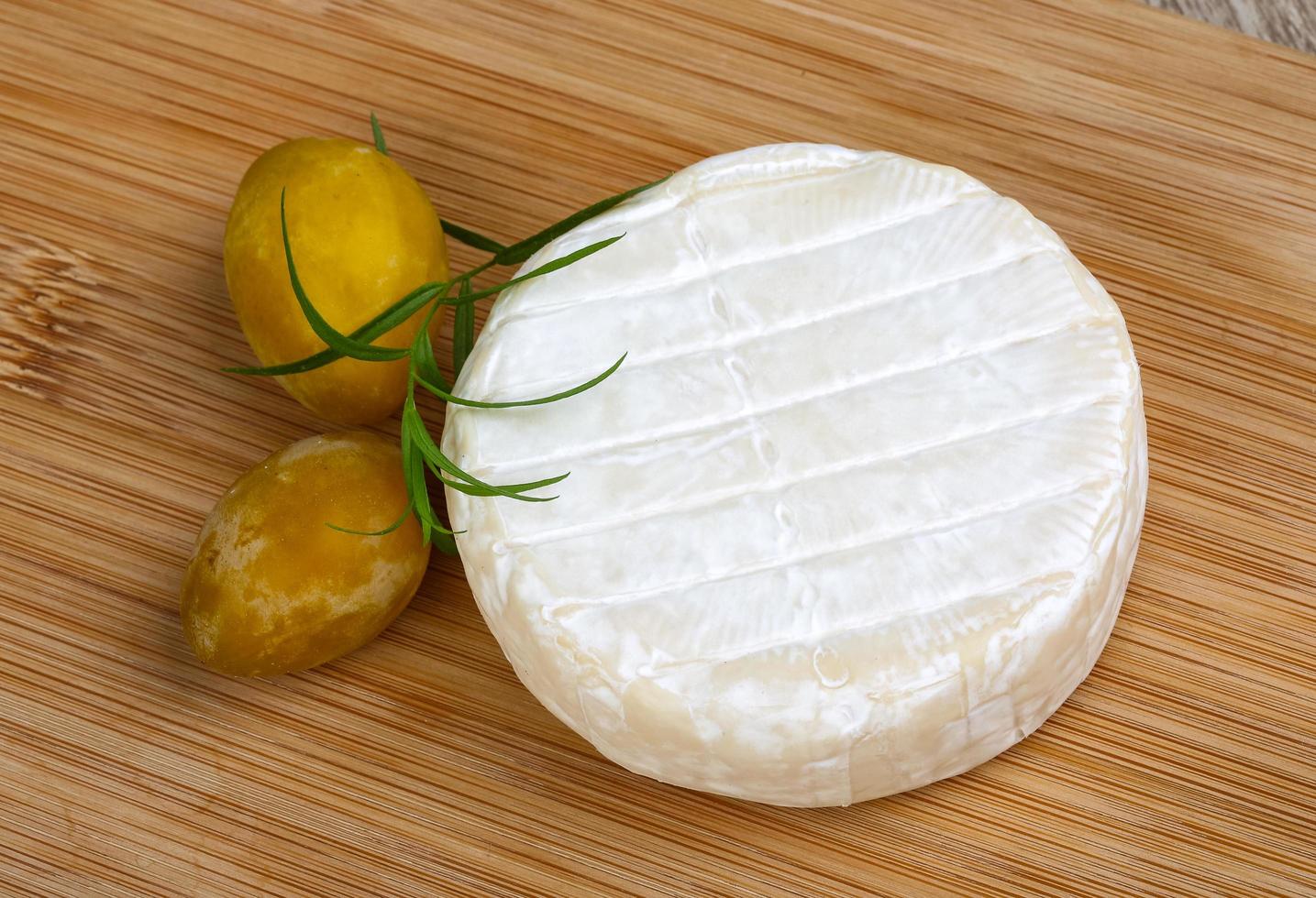 Brie cheese on wooden board and wooden background photo